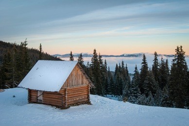tourist shelter in the winter mountains. small house in the winter mountains in the pine forest.