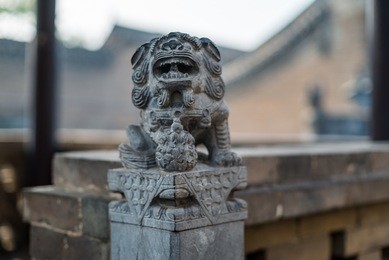 a stone dragon sculpture, part of a drum tower inside the walls of pingyao ancient city in china.