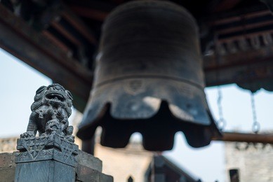 a stone dragon sculpture, part of a bell tower inside the walls of pingyao ancient city in china.
