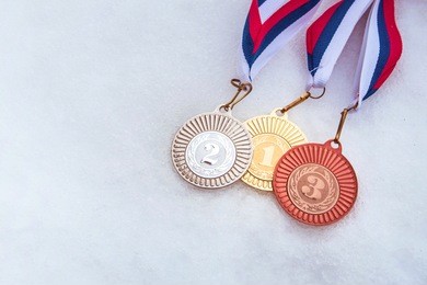 first, second, third place. medal set, white winter background.