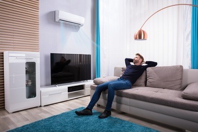 young man relaxing on sofa near television at home