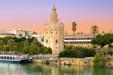 golden tower (torre del oro) at sunset from the other side of the guadalquivir river, seville (andalusia), spain.