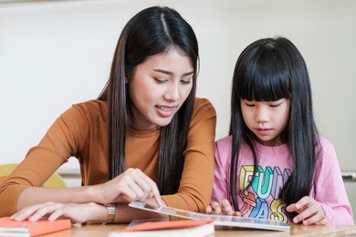 young asian woman teacher teaching girl in kindergarten classroom, preschool education concept