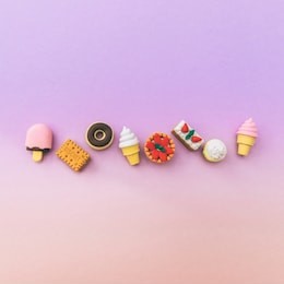 miniature sweets: ice cream, cake, cupcake, donut, pastries laid out in a line on a gradient  background. the concept of food and dessert. fashion minimal. pastel colors