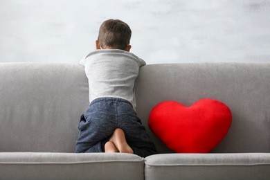 little boy sitting on sofa at home. child autism