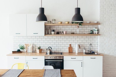 modern new light interior of kitchen with white furniture and dining table.