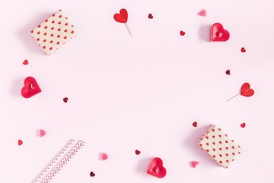 valentine's day. frame made of gifts, candles, confetti on pink background. valentines day background. flat lay, top view, copy space.
