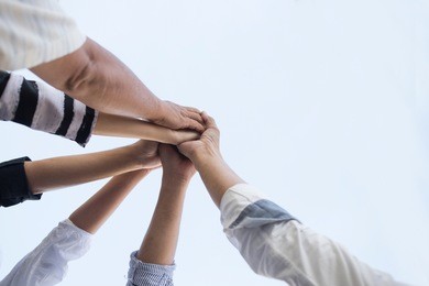teamwork group of young people putting their hands together for showing unity .