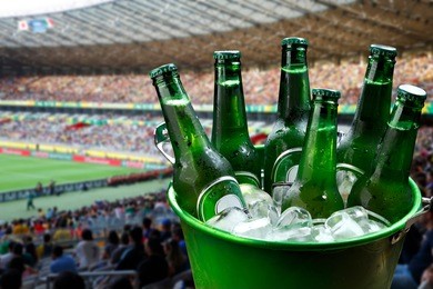 bucket with ice and bottles of beer at football stadium