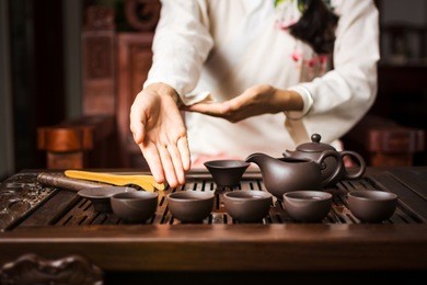 woman offering traditionally prepared chinese tea to a guest