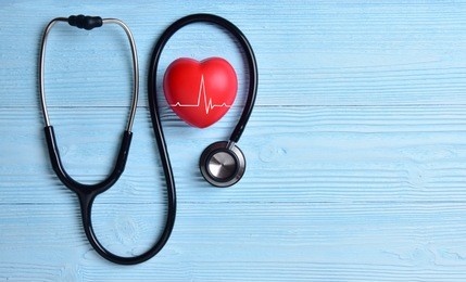 red heart with stethoscope on blue wooden background. copy space. valentines day.