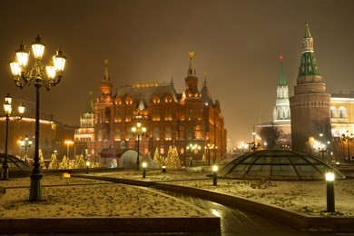 moscow, russia. state historical museum and moscow kremlin on manege square with light lamps in evening time winter.