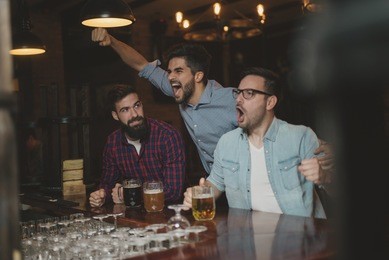 guys are drinking craft beer and watching football game.