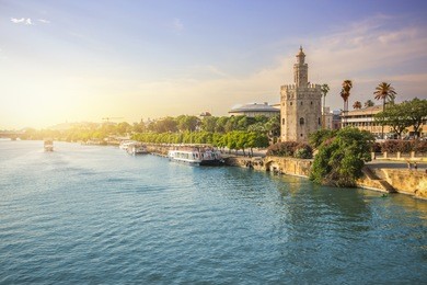 view of seville city skyline and torre del oro during sunset 