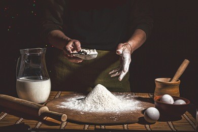 bakery. man preparing bread, easter cake, easter bread or cross-buns on wooden table in a bakery close up. man preparing bread dough.