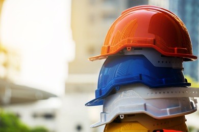 orange, blue,  white and yellow hard safety helmet hat. engineer, construction and safety concept.
copy space.