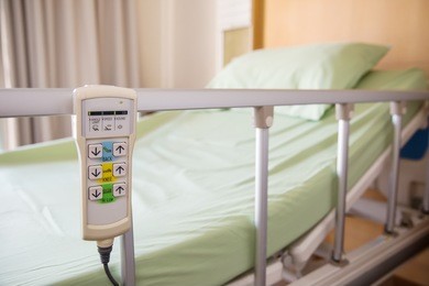 hospital bed remote control hanging on the bed rail. technology of medical and hospital services. image for background, objects, copy space, illustration and article.