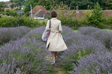a field of lavender. selective focus. selective focus. woman in beautiful cloak from back to field