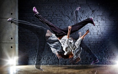 young woman dancer on wall background.