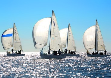 sailing regatta in greece: four back-lighted boats with spinnakers open