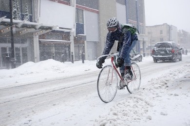 bicycle courier in winter snow storm