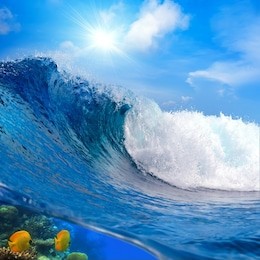 oceanview big surfing breaking ocean wave cloudy sky and the sunlight