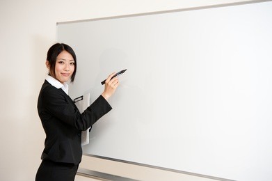 asian teacher writing to blank whiteboard