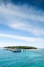tropical island with interesting cloud formations in background on vertical format (green island,cairns,qld,australia)