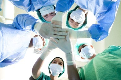 small group of doctor team joining hands,ant's eyes angle view.