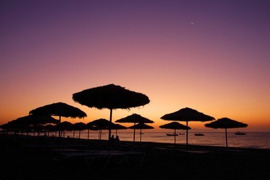 the view of sunrise at kamari beach in santorini island, greece.