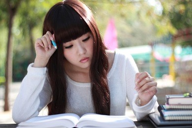 a smiling asian student is studying.