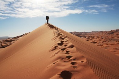 man go up in sand desert