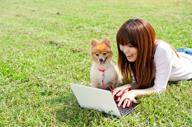 beautiful asian woman using laptop computer with dong in the park