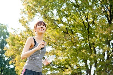 attractive asian woman running in the park