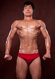 young korean bodybuilder posing in studio