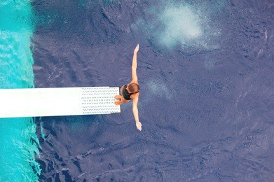 girl standing on diving board, preparing to dive