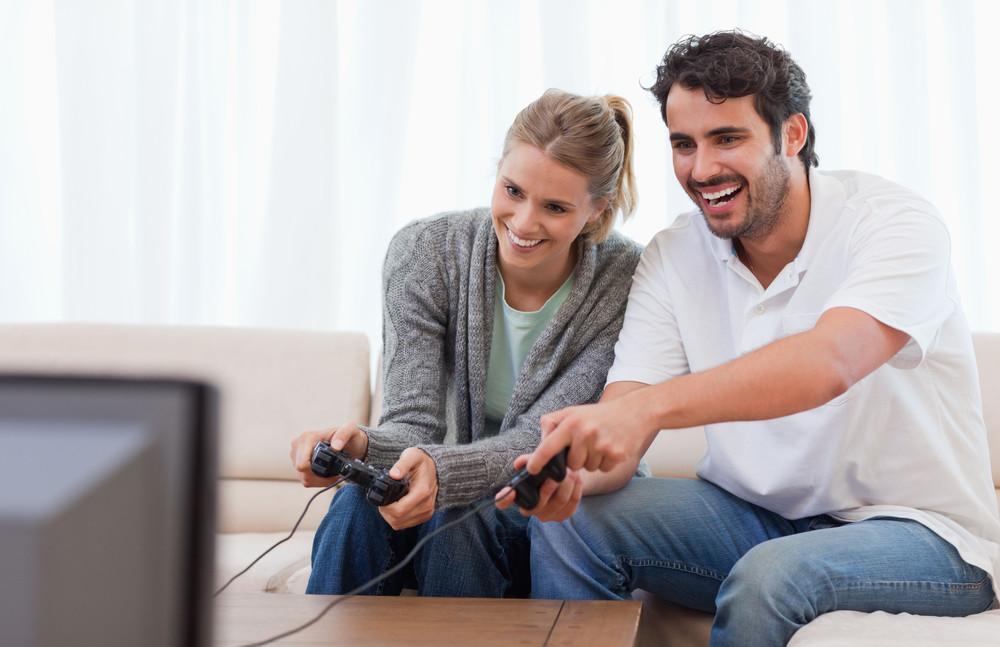 couple playing video games in their living room