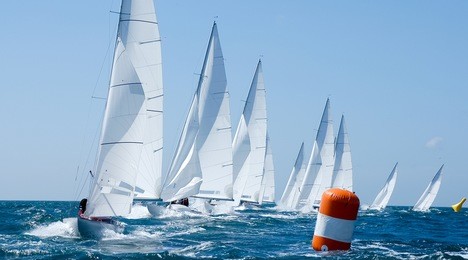 group of dragon yacht sail in regatta near a  buoy