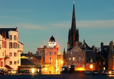 castlehill forming part of the royal mile. on the right is the hub (gothic spire), housing an information service for the edinburgh international festival. on the left is the camera obscura and shops.