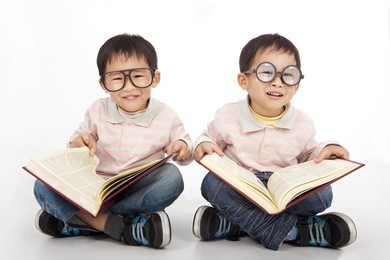happy kids with big book wearing black glasses