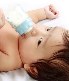 little baby drinking milk from bottle.