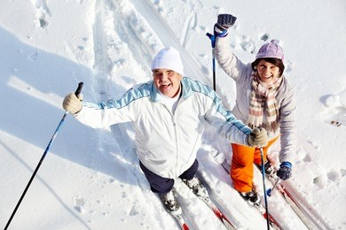 portrait of happy mature couple of skiers laughing
