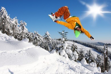 snowboarder jumping against blue sky
