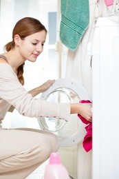 housework: young woman doing laundry (shallow dof; color toned image)