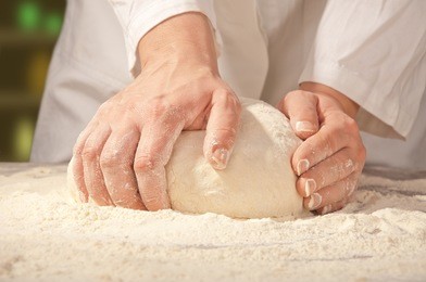 hands kneading bread dough