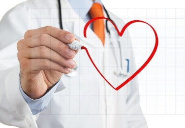 male doctor drawing heart symbol at interactive whiteboard