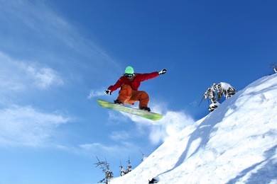 snowboarder jumping against blue sky