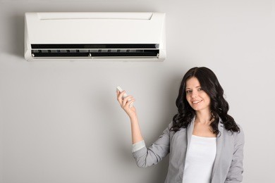 beautiful girl holding a remote control air conditioner