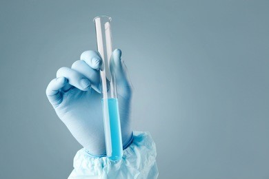 hand holding a test-tube with cyan liquid