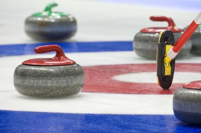 group of curling rocks on ice